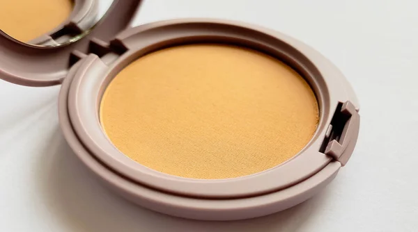 Polvo compacto para maquillaje de color natural aislado sobre un fondo blanco — Foto de Stock