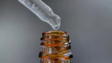 Bir damla yüz serumu olan boru ya da yüz için yağ ve güzel siyah arka planda hyaluronik asit, yakın plan.