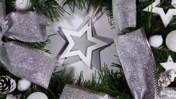 Świąteczny wieniec zdobiący frontowe drzwi na święta wykonane ze świerku, srebrnych kokardek, gwiazd i bożonarodzeniowych kulek odizolowanych na białym tle — Wideo stockowe