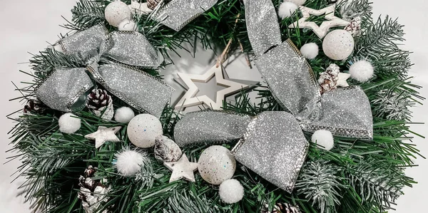 하얀 배경에는 가문비나무, 은 활, 별, 크리스마스 공으로 장식된 크리스마스 화환 이 있다. — 스톡 사진