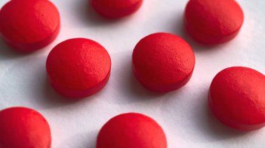 Seçici odak, beyaz arka planda izole edilmiş bir grup kırmızı ilaç. Sağlık ve tıp konsepti.