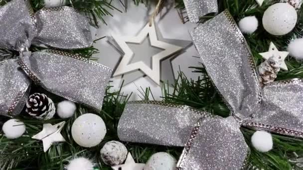 Corona de Navidad decorando la puerta principal para las fiestas hechas de abeto, arcos de plata, estrellas y bolas de Navidad aisladas sobre fondo blanco — Vídeo de stock