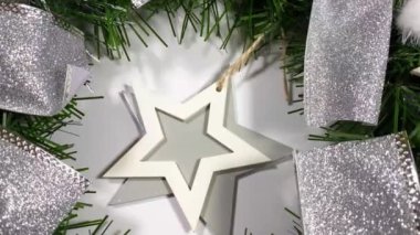 Noel çelengi ladin, gümüş yaylar, yıldızlar ve beyaz arka planda izole edilmiş Noel toplarından oluşan tatiller için ön kapıyı süslüyor.
