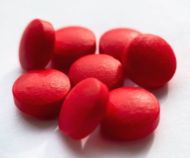 Seçici odak, beyaz arka planda izole edilmiş bir grup kırmızı ilaç. Sağlık ve tıp konsepti.