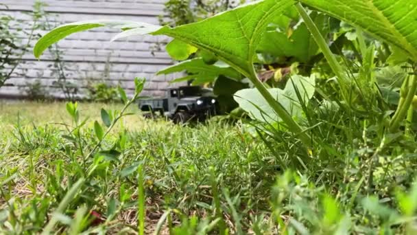 Un gran coche de carga verde oscuro con control de radio está conduciendo en el patio de una casa privada — Vídeo de stock
