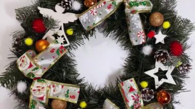 Noel çelengi ladin, gümüş yaylar, yıldızlar ve beyaz arka planda izole edilmiş Noel toplarından oluşan tatiller için ön kapıyı süslüyor.