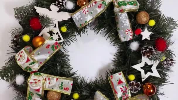 Ghirlanda di Natale che decora la porta d'ingresso per le vacanze in abete rosso, fiocchi d'argento, stelle e palle di Natale isolate su sfondo bianco — Video Stock