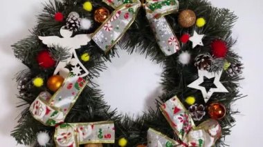 Noel çelengi ladin, gümüş yaylar, yıldızlar ve beyaz arka planda izole edilmiş Noel toplarından oluşan tatiller için ön kapıyı süslüyor.