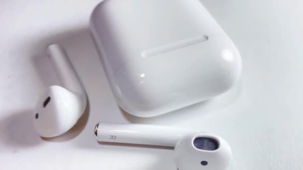 Bluetooth weiße Kopfhörer isoliert auf weißem Hintergrund im Banner-Format. Gadgets und elektronische Geräte — Stockvideo
