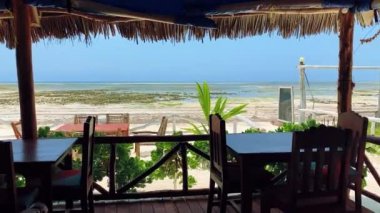 Restorandan okyanus suyuna bak dalgaların çekildiği yerde güzel mavi bir gökyüzünün arkaplanına.