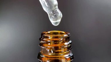 Bir damla yüz serumu olan boru ya da yüz için yağ ve güzel siyah arka planda hyaluronik asit, yakın plan.