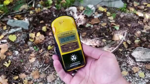 Di tangan adalah sebuah dosimeter yang mengukur tingkat radiasi terhadap latar belakang kota Pripyat di mana bencana pernah terjadi dan sejumlah besar zat radioaktif adalah — Stok Video