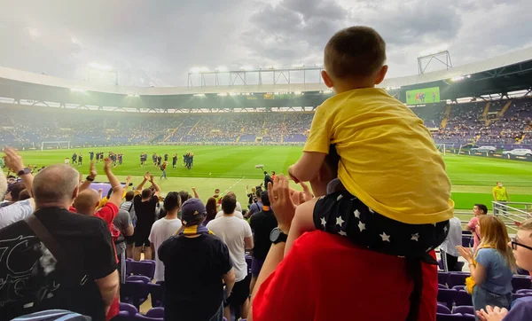 Baba ve oğul futbol stadyumunda en sevdikleri futbol takımını destekliyorlar.