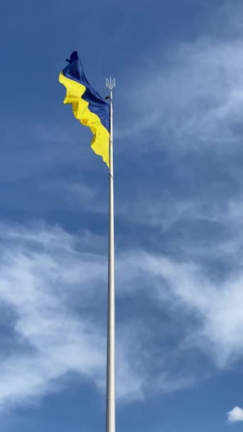 Bandera de Ucrania, colores azul y amarillo, balanceándose en el viento sobre el fondo de un cielo azul brillante. — Vídeo de stock