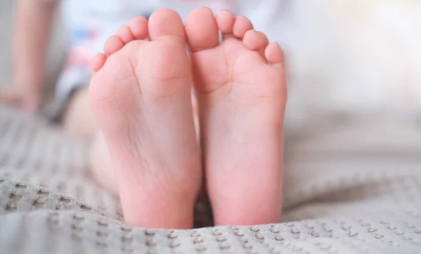 Close-up of childrens legs with feet forward — Stock Photo, Image