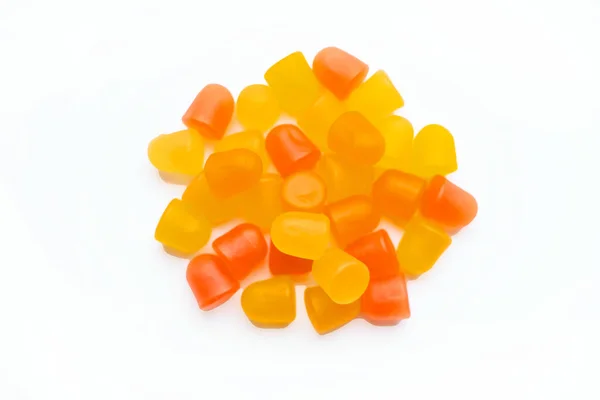 Nahaufnahme orangefarbener und gelber Multivitamingummis auf weißem Hintergrund. — Stockfoto