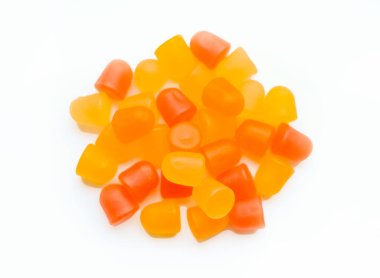 Turuncu ve sarı multivitamin sakızlarının yakın çekim dokusu beyaz arka planda ayılar şeklinde.. 
