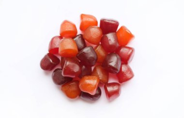 Beyaz arka planda kırmızı, turuncu ve mor multivitamin sakızları grubu var. Sağlıklı yaşam tarzı kavramı..