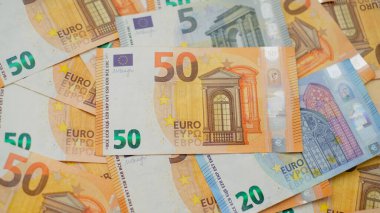 Arkaplanda farklı mezheplerden oluşan çok sayıda avro banknotları yer alıyor. Finans ve iş konsepti.