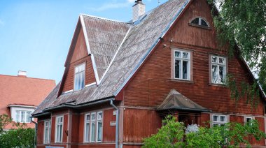 İki katlı, üçgen çatılı ve mavi gökyüzüne karşı evin yakınındaki özel bir ev..