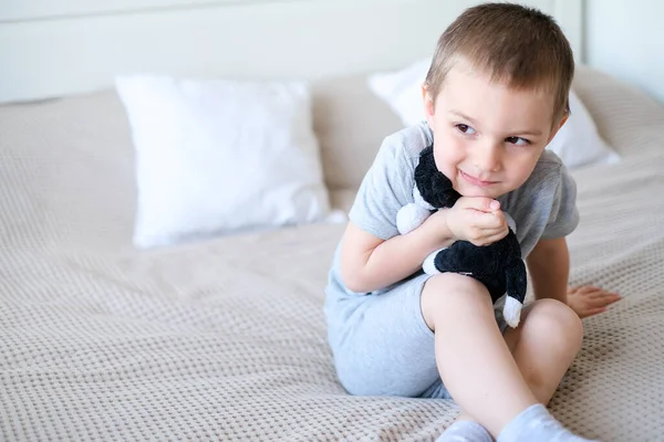 Close Small Happy Caucasian Boy Gray Shirt Lies Bed Toy — Fotografia de Stock