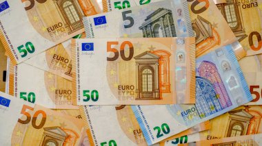 Arkaplanda farklı mezheplerden oluşan çok sayıda avro banknotları yer alıyor. Finans ve iş konsepti.