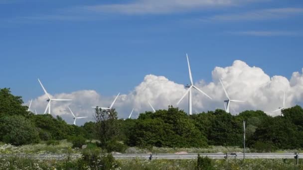 木々の後ろの天気の良い日に働く風力発電所 — ストック動画