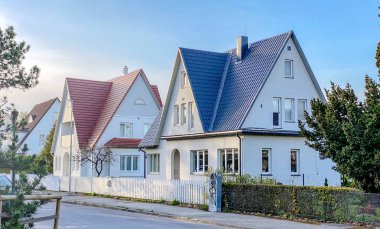 İki katlı, üçgen çatılı ve mavi gökyüzüne karşı evin yakınındaki özel bir ev..