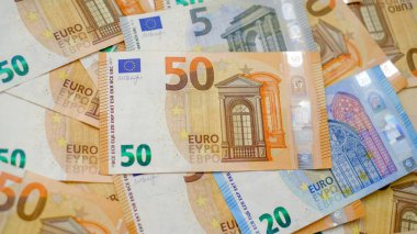 Arkaplanda farklı mezheplerden oluşan çok sayıda avro banknotları yer alıyor. Finans ve iş konsepti.