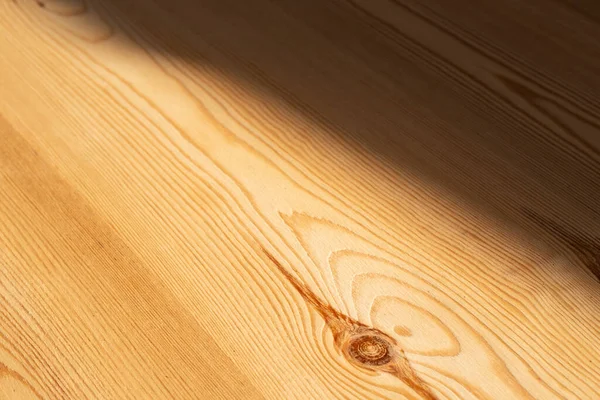 木目調の板で 片側が斜めに日陰 反対側が日当たりの良い結び目を作る — ストック写真