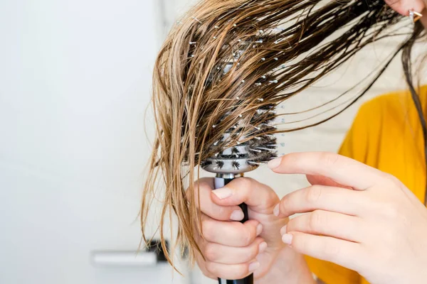 Woman combs her wet hair. Hair Brushing