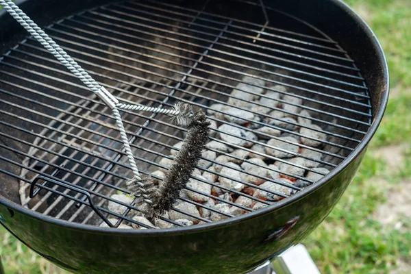 Cleaning BBQ Grill with metal brush