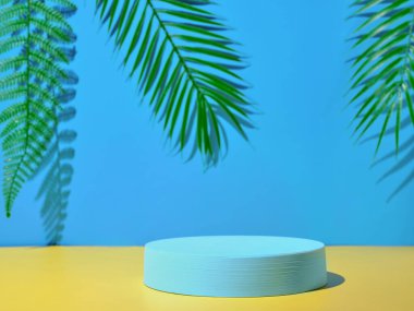 Sarı duvar ve pla karşısında ürün sunumu için mavi podyum