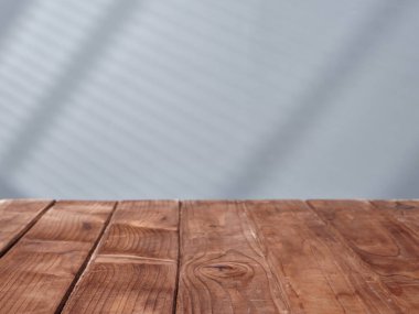 Beton bir duvarın arka planındaki tahta masa.