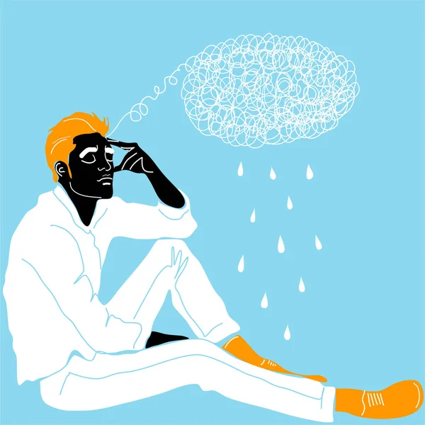 A young guy is sitting and holding his head with his hand meditating. Sadness, depression and thoughts. The concept of excitement, insecurity, mental illness, sadness and fatigue.