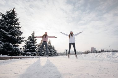 Güneşli bir kış gününde koşmadan önce iki genç atletik kız ısınma egzersizi yapıyor. Sağlıklı bir yaşam tarzı.