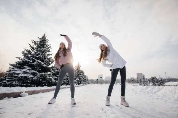 Duas Jovens Atléticas Fazem Aquecimento Antes Correr Dia Ensolarado Inverno — Fotografia de Stock