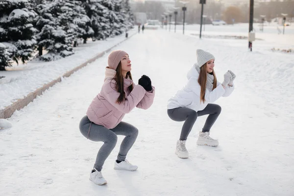 Duas Jovens Atléticas Fazem Aquecimento Antes Correr Dia Ensolarado Inverno — Fotografia de Stock