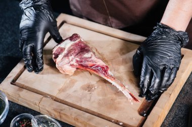 Profesyonel bir şef taze bir et parçasından sulu bir biftek pişirir ve marine eder. Gurme bir restoranda yemek pişirmek..