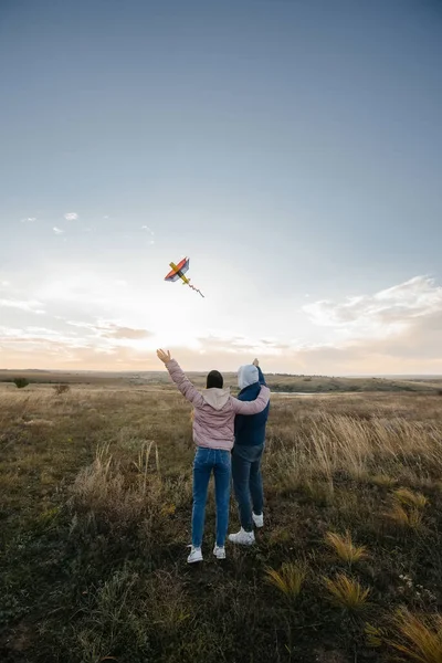 stock image A happy couple flies a kite and spends time together in the fresh air. Happy relationship and family vacation.