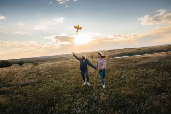 幸せなカップルは凧を飛ばし 新鮮な空気の中で一緒に時間を過ごす 幸せな関係と家族の休暇 — ストック写真