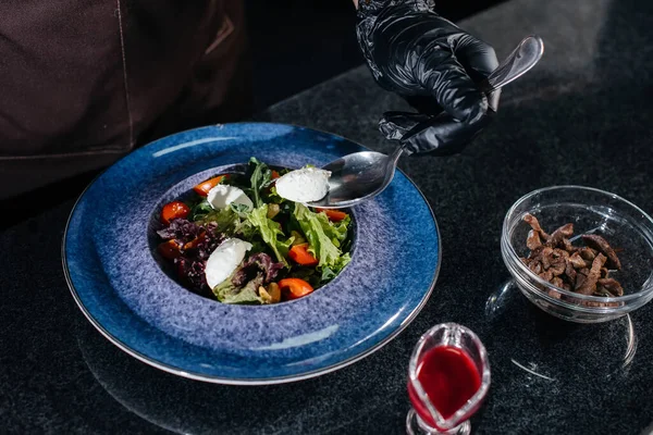 一位专业厨师在一家时尚的现代餐厅里准备了一份新鲜的蔬菜沙拉和多汁的小牛肉 在餐馆做饭 — 图库照片