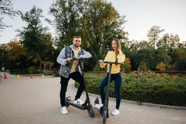 Egy Fiatal Gyönyörű Pár Elektromos Robogózik Parkban Egy Meleg Őszi — Stock Fotó
