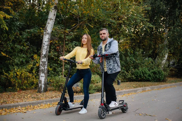 Egy Fiatal Gyönyörű Pár Elektromos Robogózik Parkban Egy Meleg Őszi — Stock Fotó