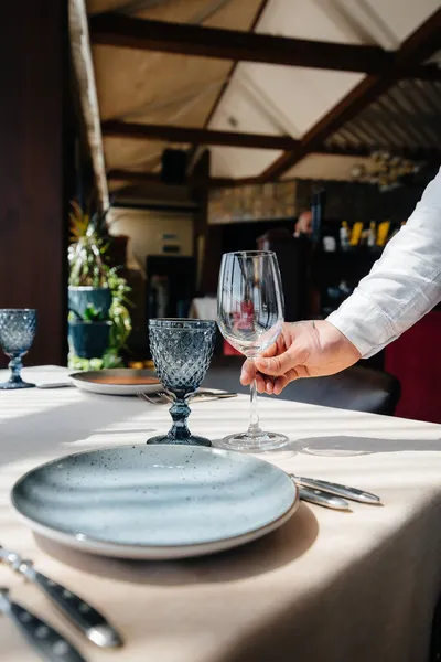 Een Jonge Ober Een Stijlvol Uniform Serveert Tafel Een Prachtig — Stockfoto