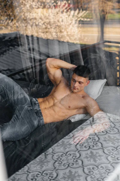 Young Sexy Athlete Perfect Abs Lies Bed Studio Topless Jeans — Stock Photo, Image