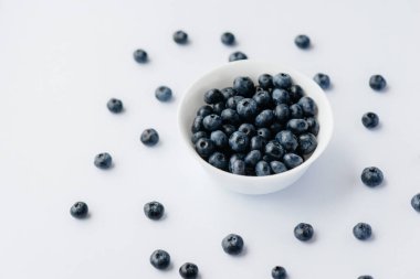 Beyaz arka planda cam bir kasede olgun yaban mersinleri. Sağlıklı yiyecek ve vitaminler..