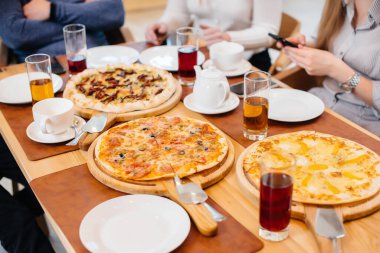 Dostça bir akşam yemeği sırasında benzersiz sıcak pizza yakın planda..