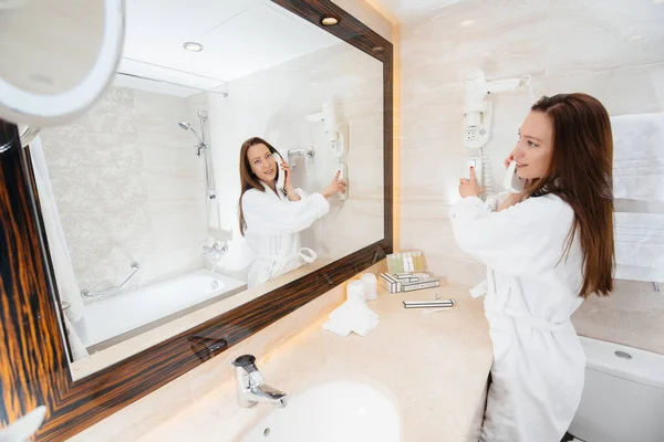 Beyaz, güzel bir banyoda telefonla konuşan güzel bir kız. Otelde taze günaydın..