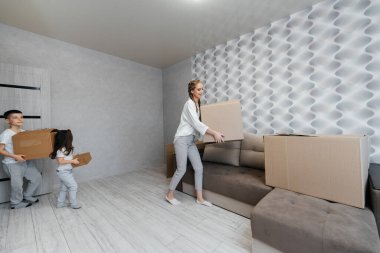 Çocuklu genç bir anne yeni bir daireye taşındıktan sonra bir kutu eşya getirir. Gayrimenkul alımı. Ev ısınması, mal teslimatı ve taşımacılığı.